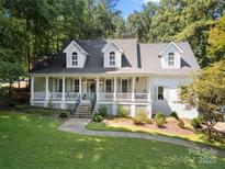 Charming white house with a welcoming front porch and beautifully landscaped front yard at 480 Robinson Rd, Mooresville, NC 28117