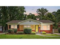 Charming single-story home with brick and stone facade, manicured lawn, and a welcoming yellow front door at 5126 Unaka Ave, Charlotte, NC 28205