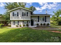 Charming home with a well-maintained lawn and a mix of brick and siding at 609 Bilmark Ave, Charlotte, NC 28213