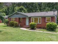 Charming single-story brick home with mature landscaping and a welcoming front porch, perfect for a cozy lifestyle at 1033 Rollingwood Dr, Charlotte, NC 28217