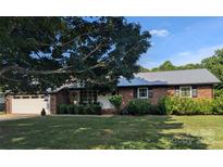 Charming brick home featuring a metal roof, well-manicured lawn, and an attached two-car garage at 3080 Shue Rd, Salisbury, NC 28147