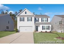 Charming two-story home with a manicured lawn, driveway, and a two car garage at 4044 Beacon Ave # 152, Monroe, NC 28110
