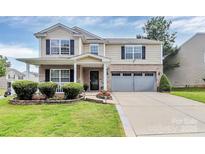 Charming two-story home featuring a well-manicured lawn, brick accents, and an attached two-car garage at 902 Silverberry St, Gastonia, NC 28054