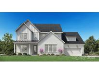 Charming two-story home featuring a brick-and-board facade, attached two-car garage, and manicured front lawn at 5337 Mint Harbor Way # 0302, Charlotte, NC 28269