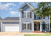 Charming two-story home with blue siding, black shutters, and well-maintained landscaping at 6930 Culloden More Ct, Charlotte, NC 28217