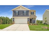 Charming two-story home featuring a two-car garage, manicured lawn, and classic architectural details at 143 Astor St, Troutman, NC 28166