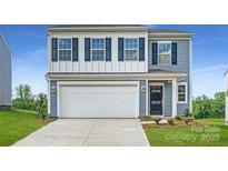 Charming two-story home with a two-car garage, blue accents, and well-manicured lawn at 149 Astor St, Troutman, NC 28166