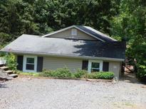 Cozy bungalow home with a gravel driveway and lots of surrounding trees at 257 Rolling View Dr, New London, NC 28127