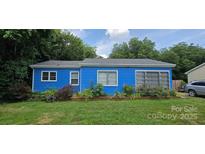 Charming blue home with white window frames and a manicured lawn at 1904 E Innes St, Salisbury, NC 28146