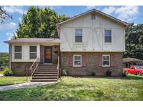 Two-story brick home with a well-manicured lawn and inviting front staircase at 421 Vickery Dr, Charlotte, NC 28215