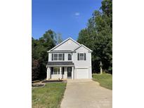 Charming two-story home featuring gray siding, black shutters, an attached garage, and a well-manicured lawn at 961 Poplar Forest Rdg, Clover, SC 29710