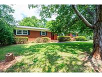 Charming brick home features a well-manicured lawn and mature shade trees at 1008 2Nd Se St, Conover, NC 28613