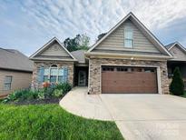 Single-story home featuring a stone facade and a well-manicured front yard with flower beds at 194 T R Harris Dr, Shelby, NC 28150