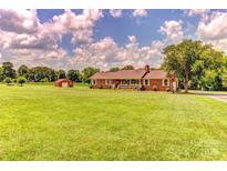 Expansive front lawn leading up to a traditional brick home and detached garage at 404 Baxter Rd, Cherryville, NC 28021