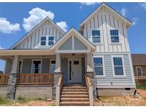 Charming two-story home featuring white siding, multiple windows, and a welcoming front porch and stairway at 105 Macland Ln # 540, Rock Hill, SC 29730