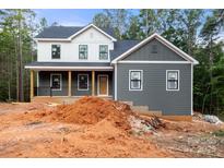 Two-story home featuring a welcoming front porch and gray and white siding in a wooded neighborhood at 4615 Yellow Poplar Ln, Concord, NC 28025