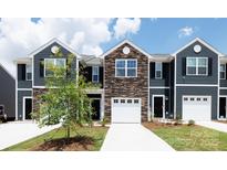 Charming townhome showcasing stone accents, driveway, attached garage, and well-maintained landscaping at 522 Trading Post Ln, York, SC 29745