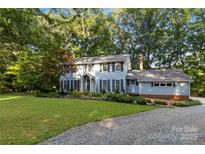 Charming two-story home with a manicured lawn, lush landscaping, and beautiful trees at 601 Highland Forest Dr, Charlotte, NC 28270