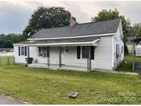 Cozy single-Gathering home with white siding, a well-maintained lawn, and a classic architectural style at 104 Franklin St, Clover, SC 29710