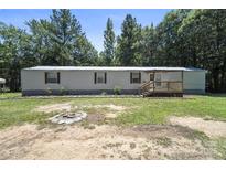Quaint home featuring a covered front porch and spacious yard surrounded by mature trees, offering privacy at 1354 Springwood Ln, Rock Hill, SC 29730