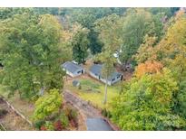 Scenic aerial view of a charming home nestled among lush trees with a long driveway and detached garage at 7101 Signer Rd, Charlotte, NC 28278
