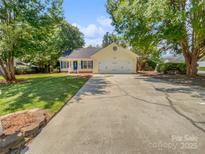 Charming home featuring blue shutters, a well-manicured lawn, and a long driveway, with mature trees offering shade at 1634 Dawson Ct, Rock Hill, SC 29730
