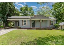Charming single-story home featuring gray siding, a covered carport, and a well-maintained front lawn at 3015 Lasalle St, Charlotte, NC 28216