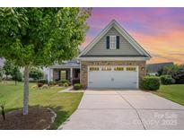 Charming brick home featuring a well-maintained lawn and a two-car garage, providing comfortable suburban living at 7015 Gracefield Ln, Fort Mill, SC 29707