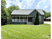 Charming stone-clad home featuring a welcoming front porch and a well-manicured lawn at 1004 Venus St, Kannapolis, NC 28083