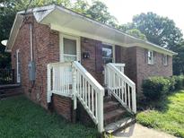Charming brick home with a white railed front porch and well-maintained yard at 28 Maiden Ln, York, SC 29745