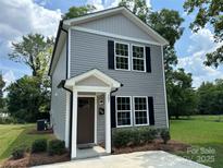 Charming two-story home featuring gray siding, black shutters, and a well-manicured front yard at 307 Messner St, Salisbury, NC 28144