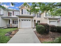 Charming townhome featuring a one-car garage, beige siding, and black shutters, complemented by lush landscaping at 321 Rose Garden Ct, Rock Hill, SC 29732