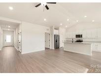 Bright, open-concept living room flows into modern kitchen, featuring stainless steel appliances and granite countertops at 3457 Bear Den Dr, Gastonia, NC 28052
