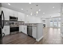 Modern kitchen boasts stainless appliances, granite counters, and a breakfast bar open to the adjacent living area at 4211 Center Place Dr, Harrisburg, NC 28075