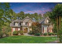 Charming two-story home with manicured lawn, stone accents, red shutters, and lush landscaping at 4552 Sawgrass Ct, Denver, NC 28037