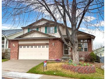 Charming two-story brick home with a well-manicured lawn and a large shade tree in the front yard at 13661 Adams St, Thornton, CO 80602