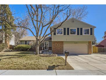 Charming two-story home with a well-manicured lawn and a two-car garage at 8210 Hoyt Ct, Arvada, CO 80005