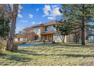 Two-story home with a landscaped yard, portico, and a beautiful brown tile roof at 8544 Burning Tree Trl, Franktown, CO 80116