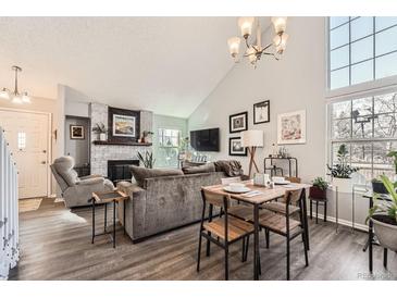 Open concept living space with fireplace, dining area, and lots of natural light at 8391 W 90Th Pl, Westminster, CO 80021