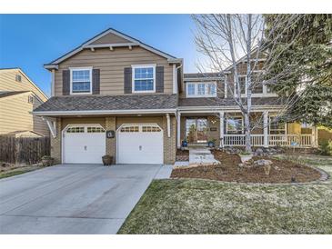 Charming two-story home featuring a well-maintained front yard and a convenient two-car garage at 7273 E Hinsdale Pl, Centennial, CO 80112