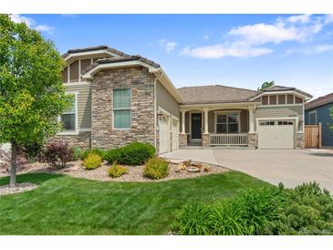 Charming home with a stone and siding exterior, well-manicured lawn, and a three-car garage at 10182 Bristleridge St, Parker, CO 80134