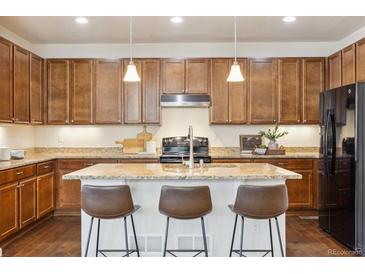 Beautiful kitchen featuring stainless steel appliances, granite countertops, and a central island with barstool seating at 7367 S Pennsylvania St, Littleton, CO 80122