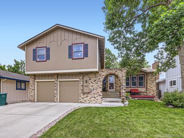 Two-story home with brick and stucco, featuring an arched brick entryway and a well-manicured lawn at 9150 Garrison St, Broomfield, CO 80021