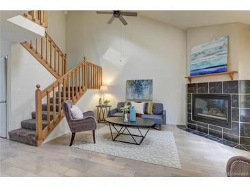 Cozy living room features a fireplace and hardwood floors at 3813 E 121St Ave, Thornton, CO 80241