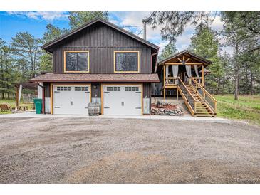 Charming two-story home featuring a two-car garage and detached covered porch with stairs at 33844 Oriole Ct, Elizabeth, CO 80107