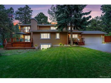 Charming two-story home featuring a well-manicured lawn and a spacious deck, perfect for outdoor entertaining at 1540 Fawnwood Rd, Monument, CO 80132