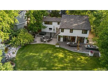 Expansive backyard featuring a patio, hot tub, and lush green lawn, perfect for outdoor entertaining and relaxation at 3235 E Easter Pl, Centennial, CO 80122