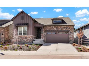 Charming two-story home featuring a stone and wood facade, landscaped front yard and a two-car garage at 8052 Mount Kataka St, Littleton, CO 80125