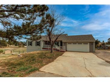 Charming single-Gathering home featuring a two-car garage, covered front porch, and landscaped front yard at 1233 Starling Ln, Elizabeth, CO 80107