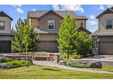 Charming two-story home featuring a bench in the front yard with lush landscaping and an attached two-car garage at 10401 Maplebrook Way, Highlands Ranch, CO 80126
